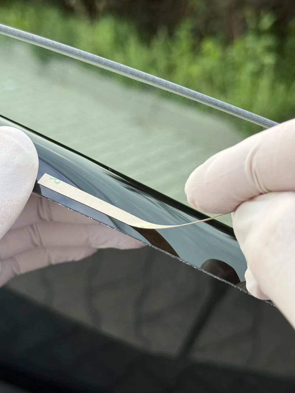 Applying clear 3M tape strips along the edge of the panel